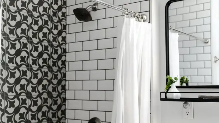 White fabric shower curtain on a chrome rod beside white subway tile