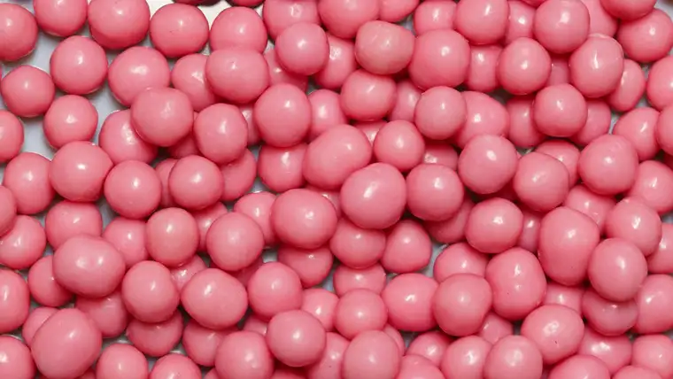Pile of round pink bubble gum pieces filling the frame